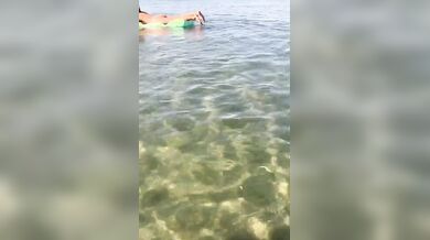 Moglie nuda sul materassino al mare