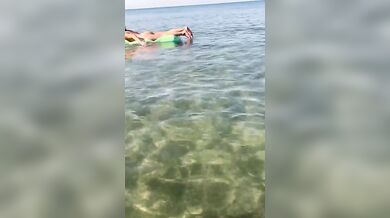 Moglie nuda sul materassino al mare