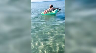 Moglie nuda sul materassino al mare