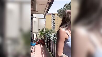 In live mentre stende i panni sul balcone