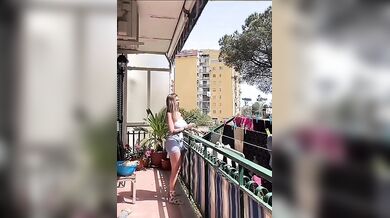 In live mentre stende i panni sul balcone