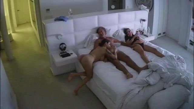 Fa un pompino al patrigno in camera da letto con la mamma che la guarda